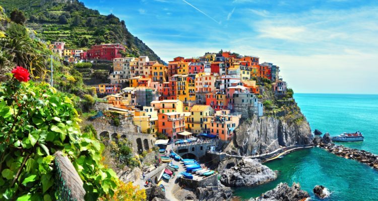 Colourful houses above a rocky harbour in Cinque Terre.